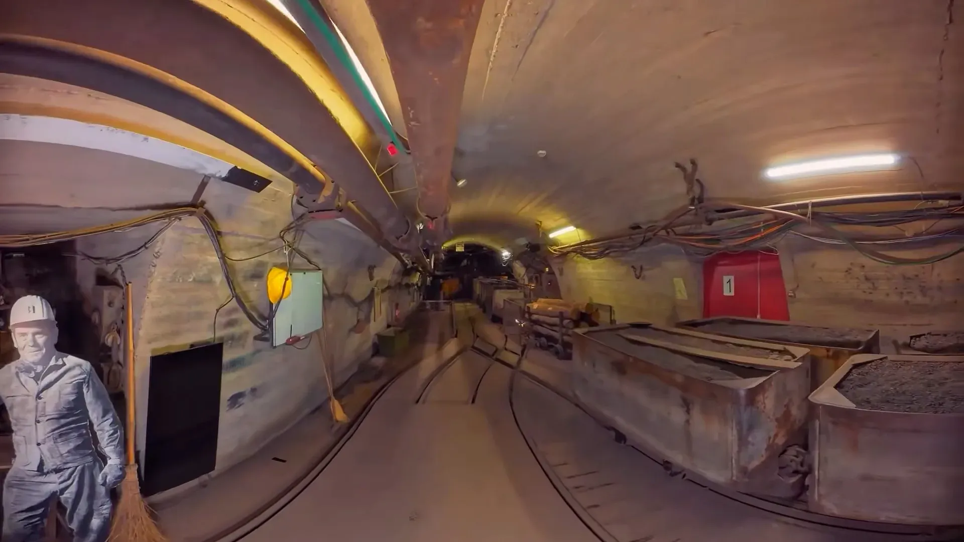 Galerie éclairée, rails et berlines, avec un mineur reconstitué, musée de la mine de Saint-Étienne