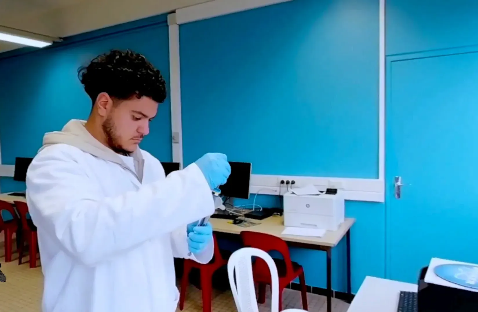 Étudiant en blouse qui pipette dans un laboratoire de l’IUT d’Orsay, film immersif