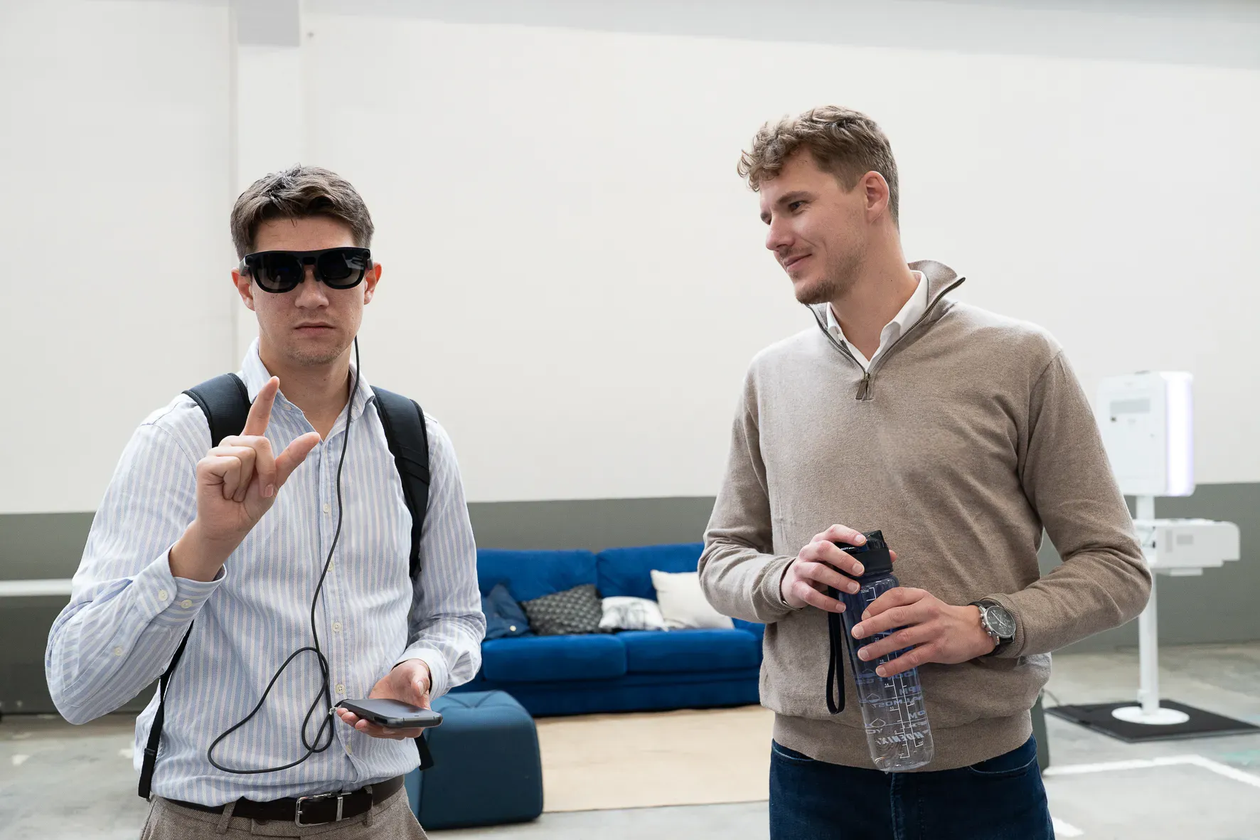 Un visiteur porte des lunettes de réalité augmentée reliées à un téléphone.