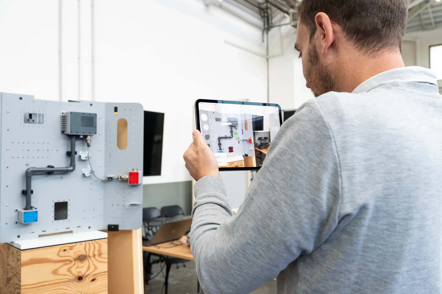 Une tablette affiche un banc technique industriel augmenté d’informations en réalité augmentée.
